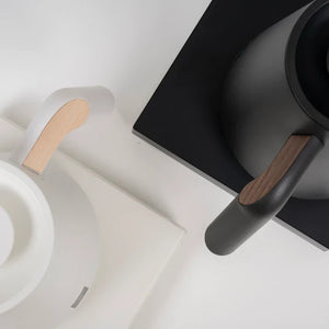 Wäiss a schwaarzen elektresche Waasserkecher mat Holzdetailler um Grëff, präzise Floss fir Barista-Brouwen, alles ëm de Kaffi.